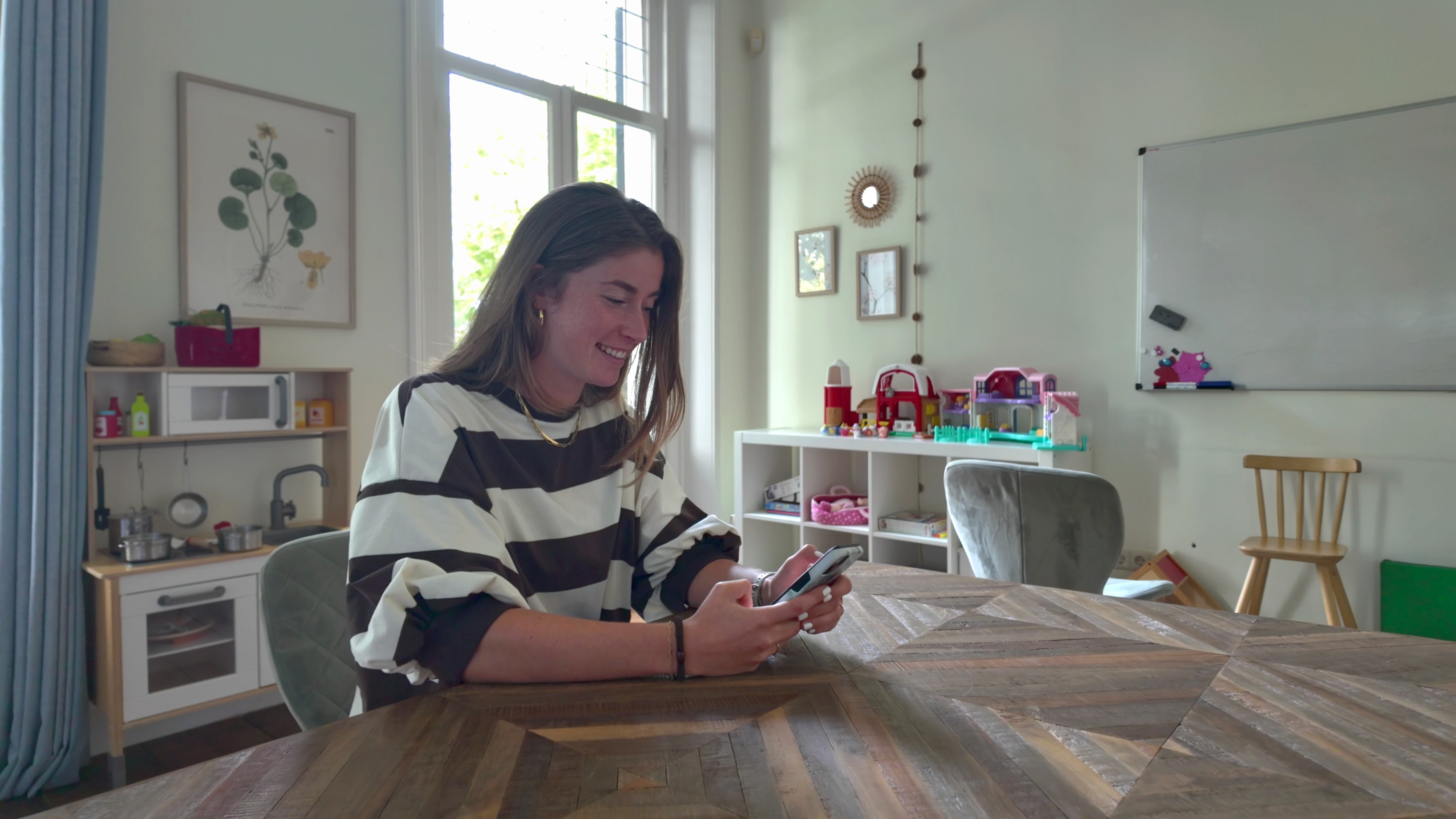 Een medewerker van Kind & meer gebruikt haar telefoon in een gespreksruimte